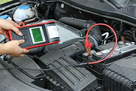 battery tester connected to car battery